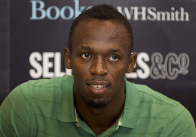 Jamaican athlete Usain Bolt poses for photographers as he signs copies of his autobiography, "Faster than Lightning,"  at Selfridges in central London September 19, 2013. REUTERS/Neil Hall (BRITAIN - Tags: ENTERTAINMENT SPORT ATHLETICS SOCIETY)
