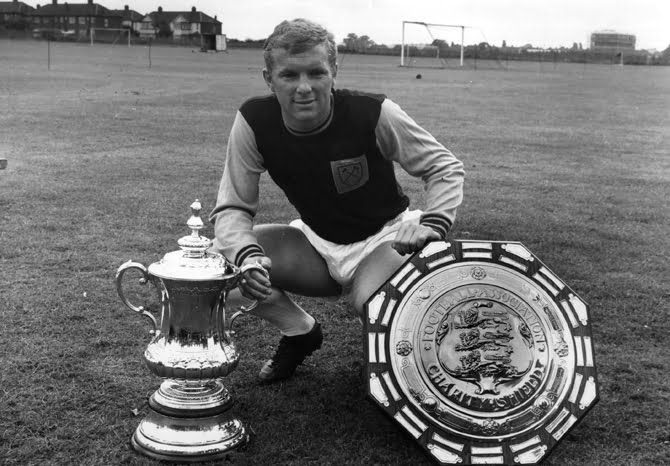 18th August 1964: West Ham United captain Bobby Moore (1941 - 1993) with the FA Cup and Charity Shield trophies. (Photo by Fox Photos/Getty Images)