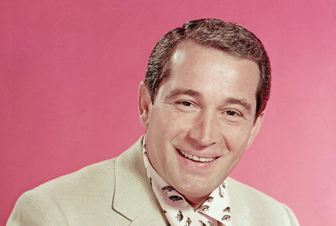 Portrait of popular American singer Perry Como (1912 - 2001) as he sits in a pink and black shirt under a light tan jacket, mid 1950s. (Photo by Hulton Archive/Getty Images)