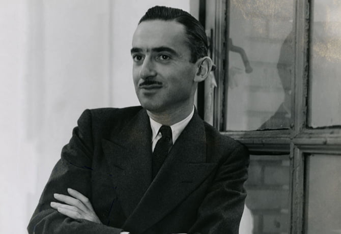 Proof: Long-time creative director for Conde Nast Publications, Alexander Liberman stands in front of window with arms crossed and one leg resting on the window sill