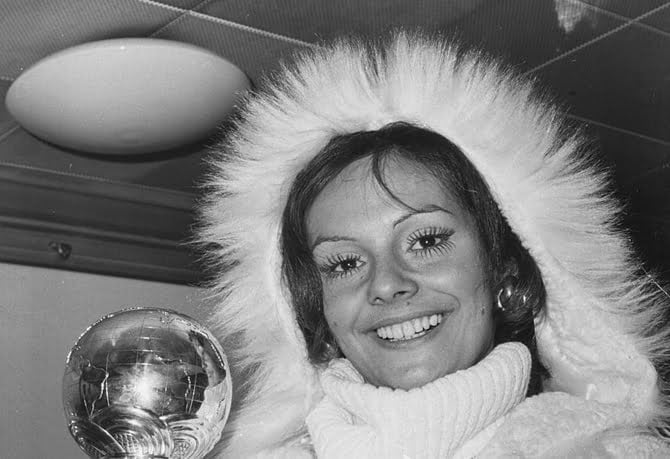 Newly crowned 'Miss World' winner Lucia Petterle from Brazil is holding her trophy and smiling, wrapped up against the cold as she prepares to fly home from Heathrow Airport, London, November 21st 1971. (Photo by Keystone/Hulton Archive/Getty Images)